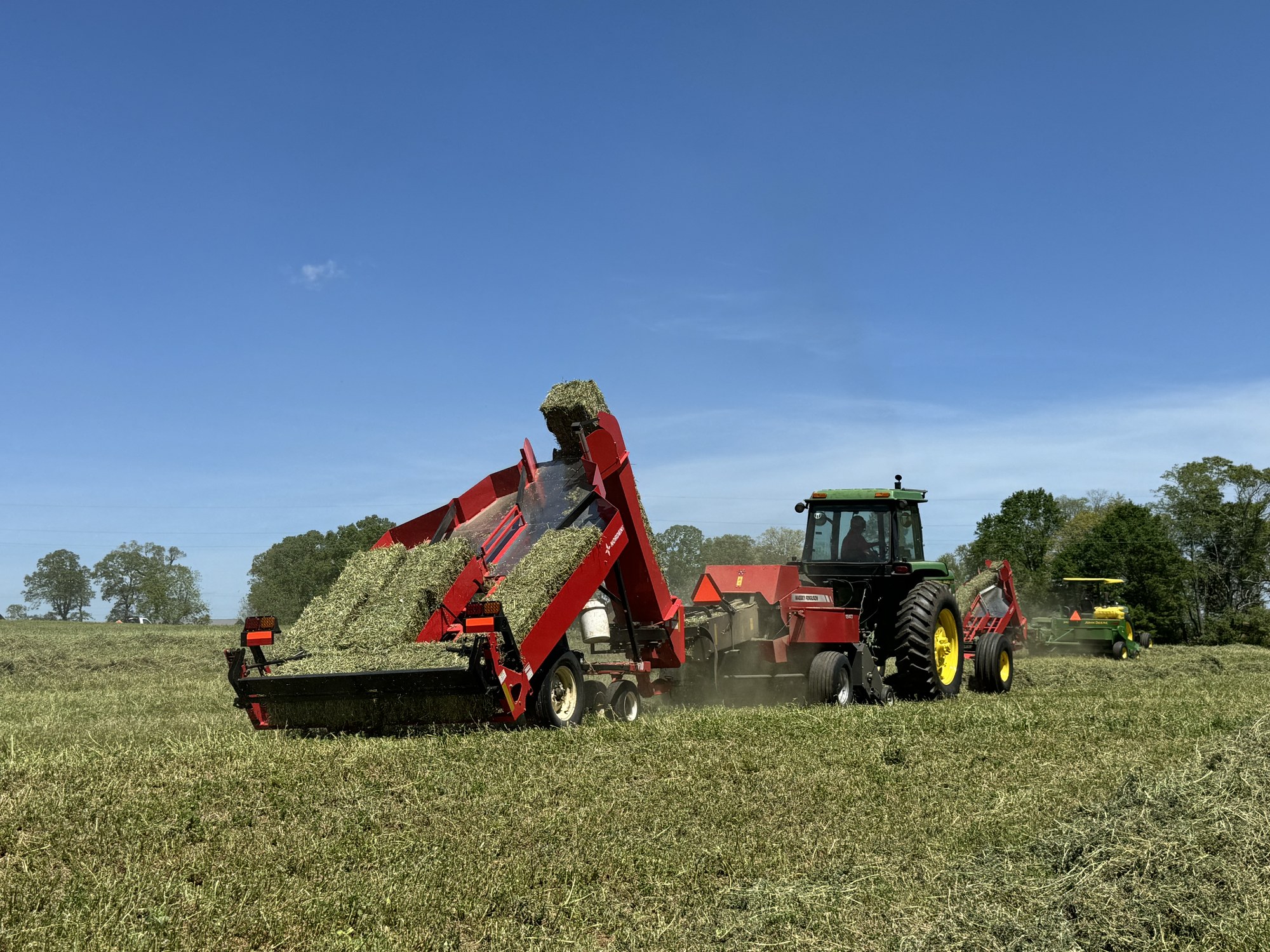 Bale accumulator stacking square bales with hay flying