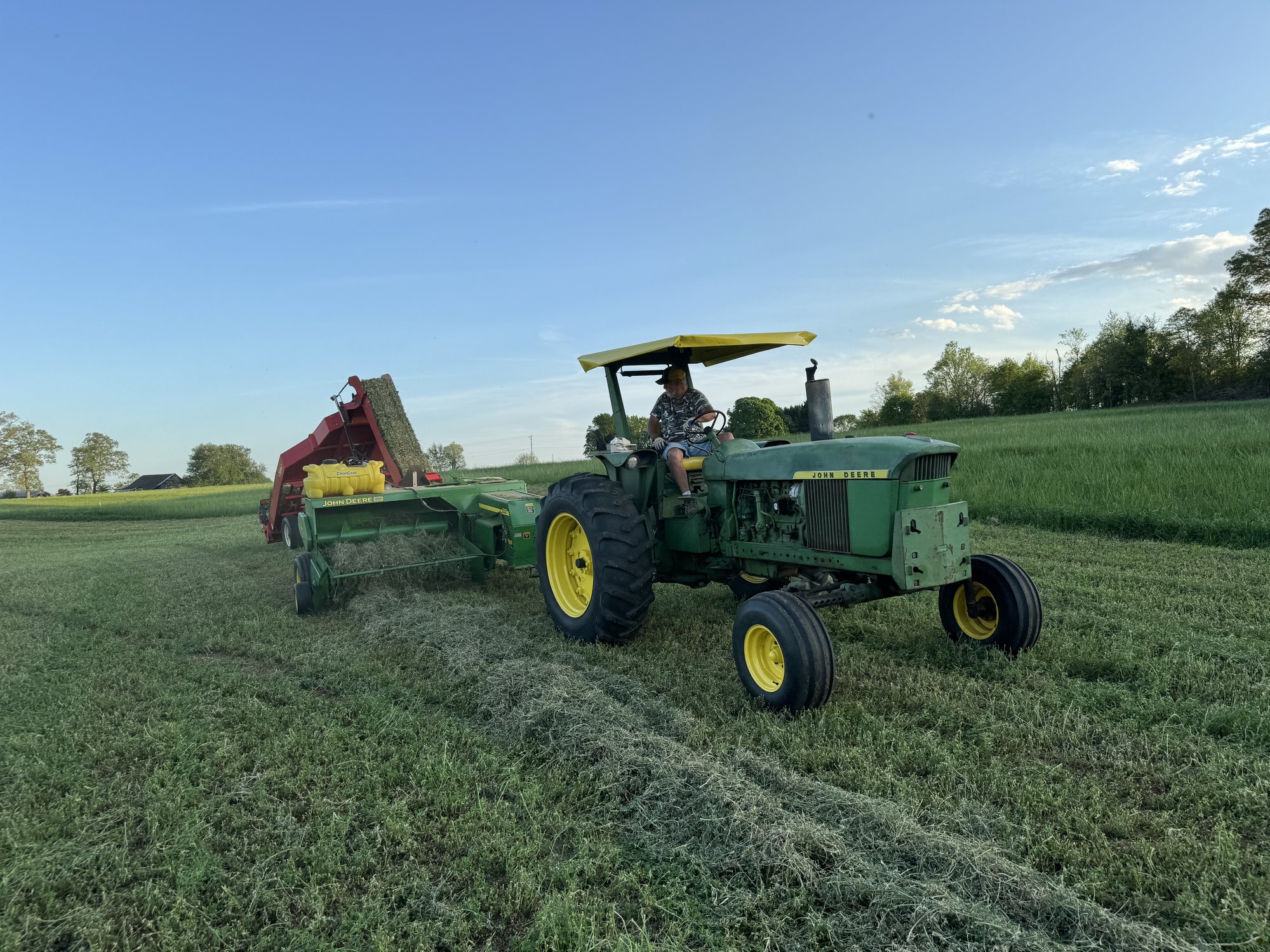John Deere baler and accumulator working at golden hour