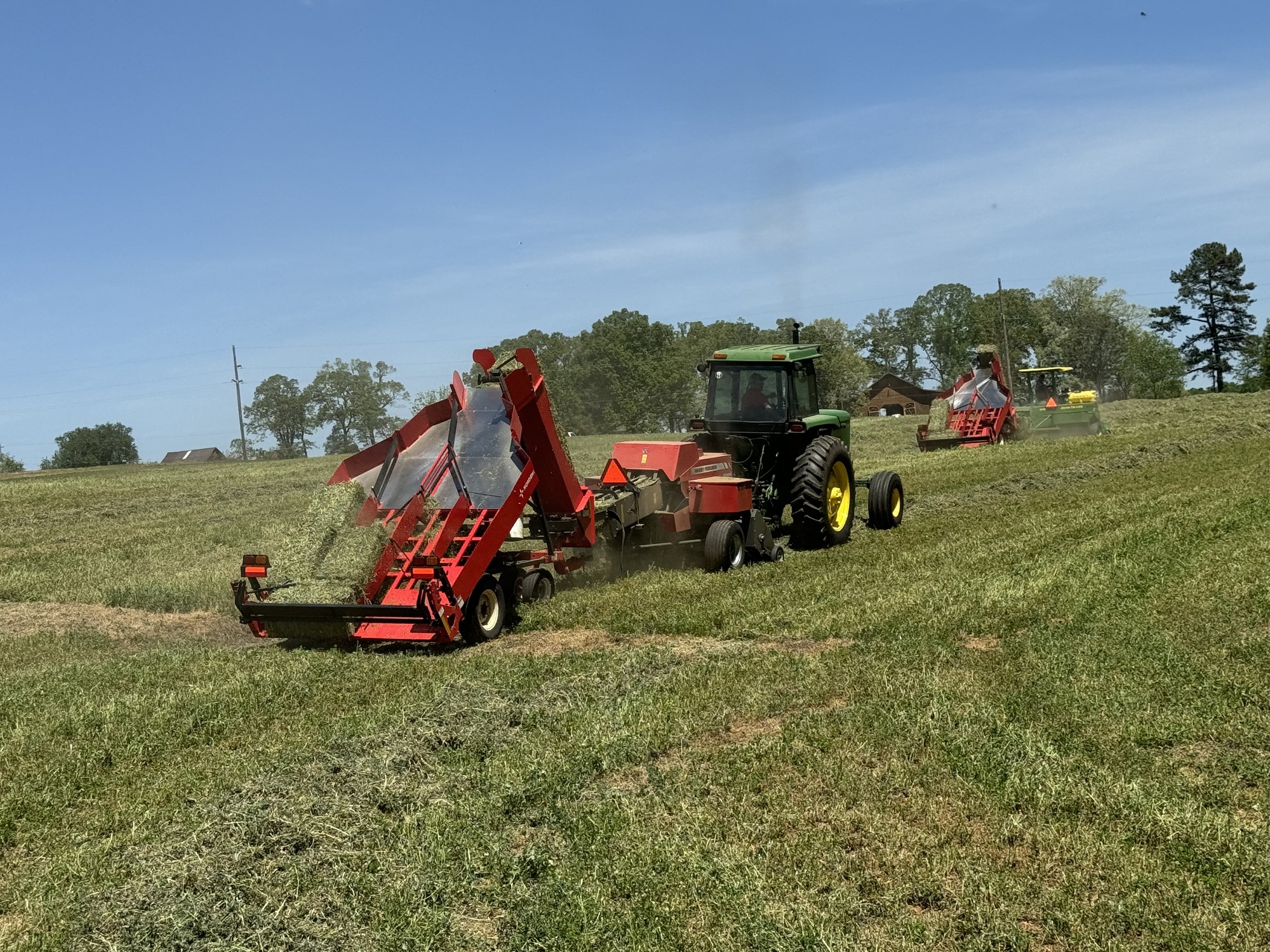 Square baler in action behind a John Deere tractor