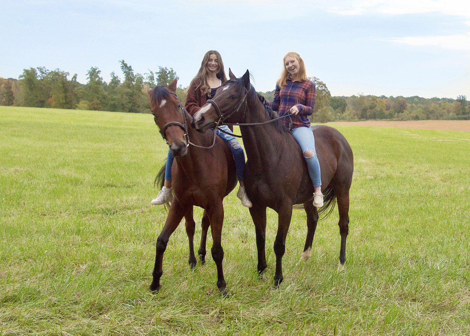 Two riders in the pasture on a fall afternoon